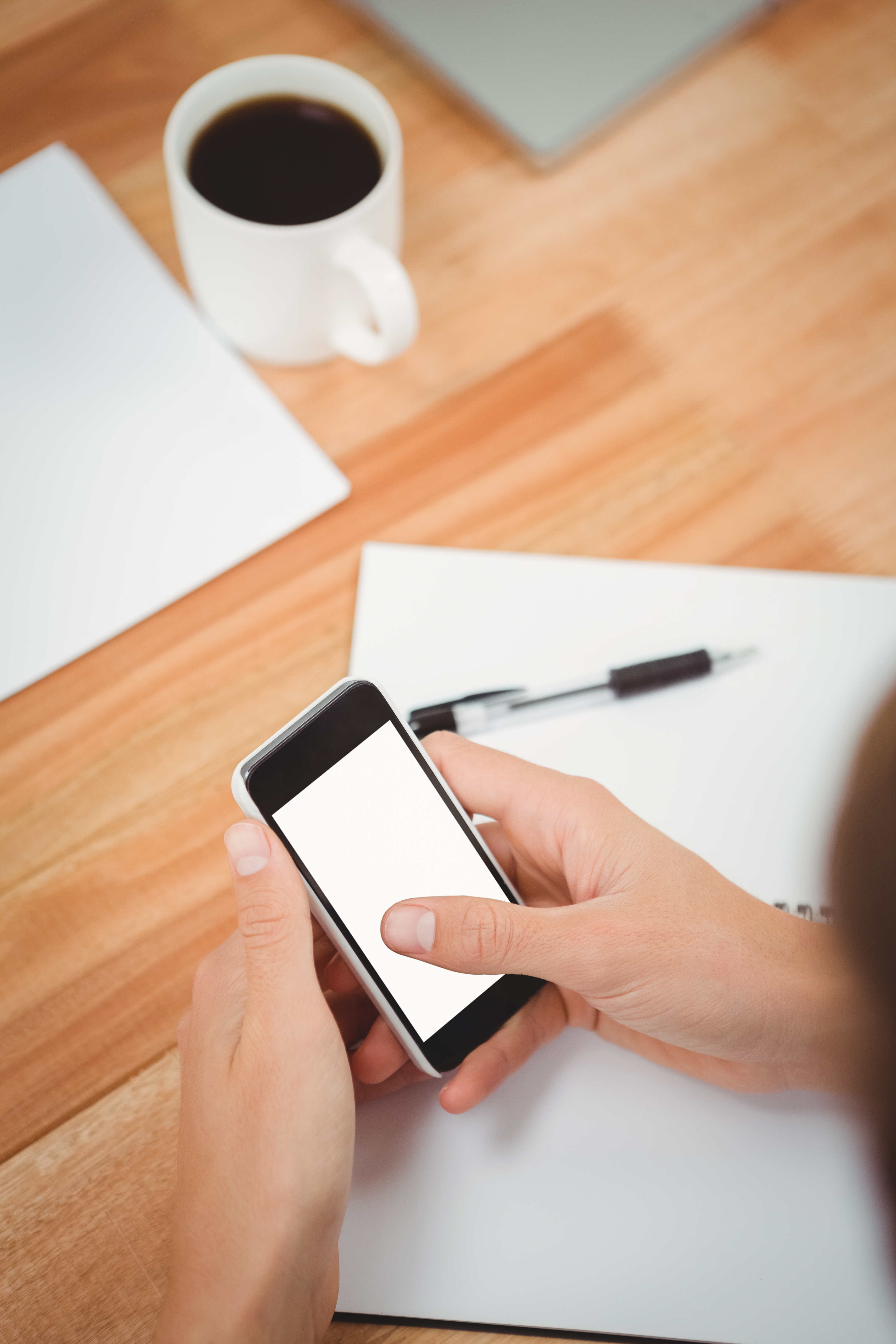 Business professional reviewing messaging on a smartphone at a desk