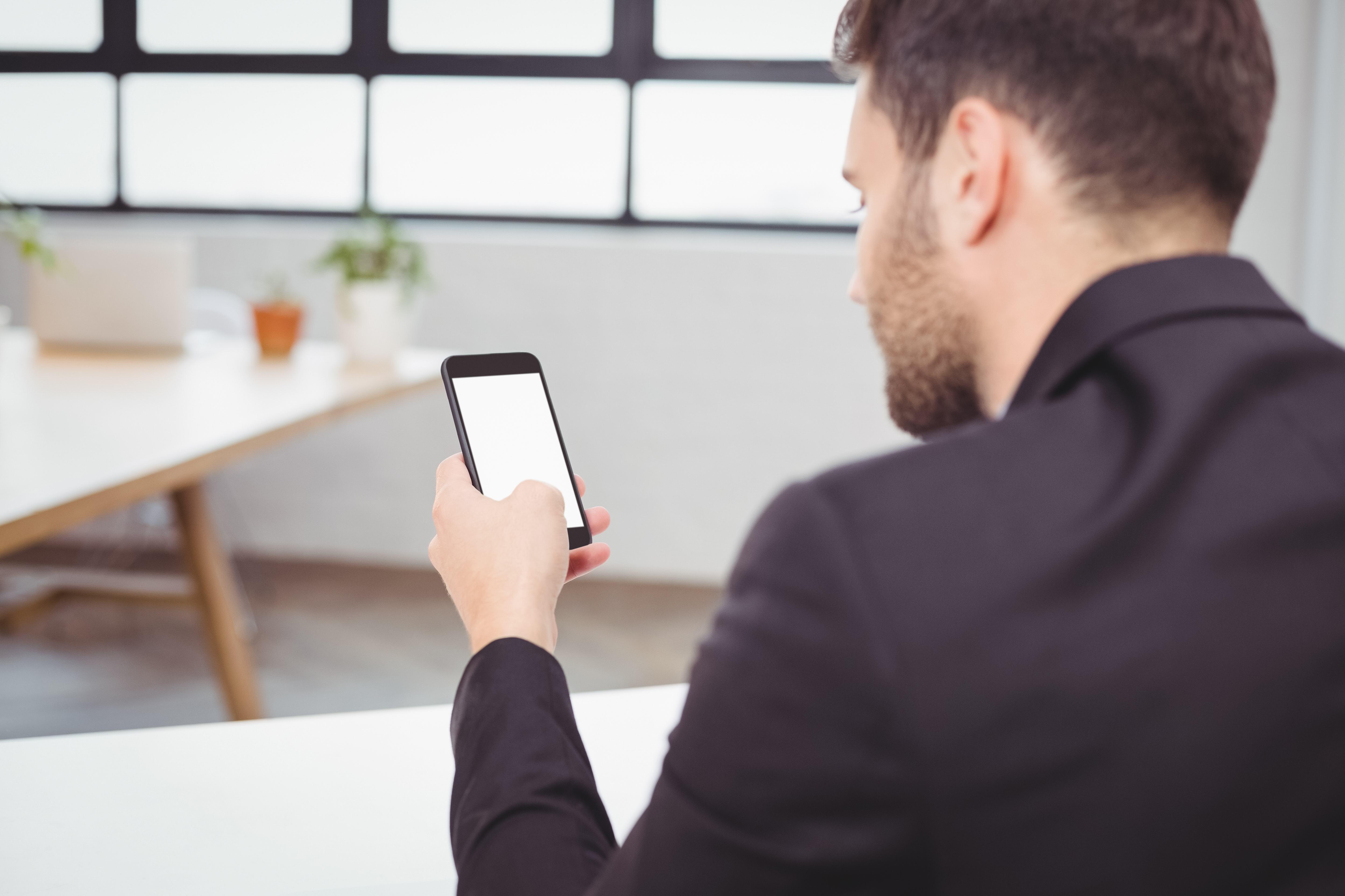 Business user checking mobile notification updates in an office